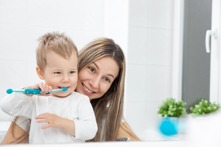 mom teaching son how to brush teeth